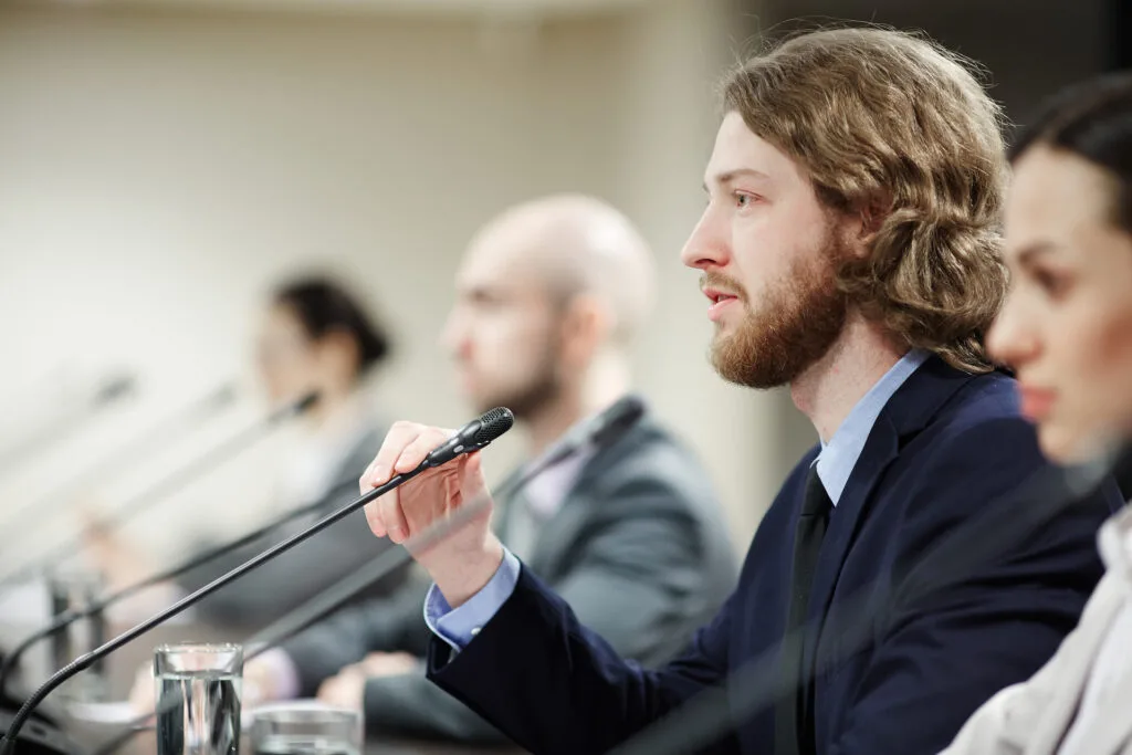 speaker-addressing-audience-in-conference-room-2026-09-22-02-58-53-utc (1)
